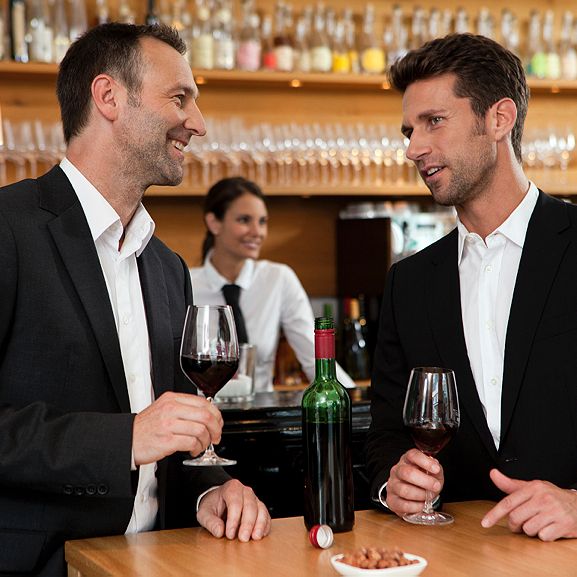 Men drinking wine at bar