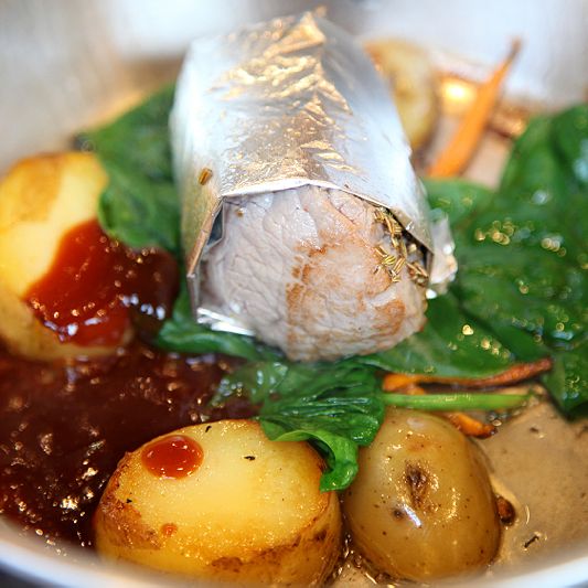 Meat in aluminium foil on potatoes