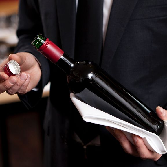 Red wine bottle with screw cap in hands