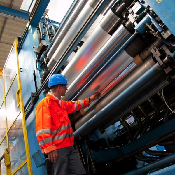 Worker inspecting aluminium press